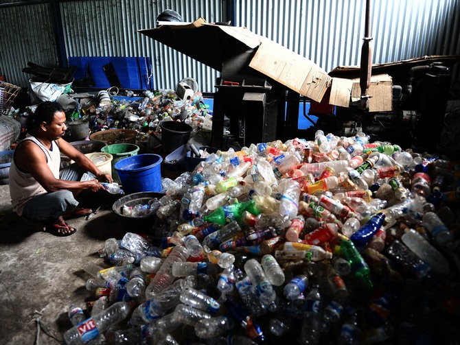 A man sorts through garbage in Surabaya, Indonesia. (Photo by Robertus Pudyanto/Getty Images)